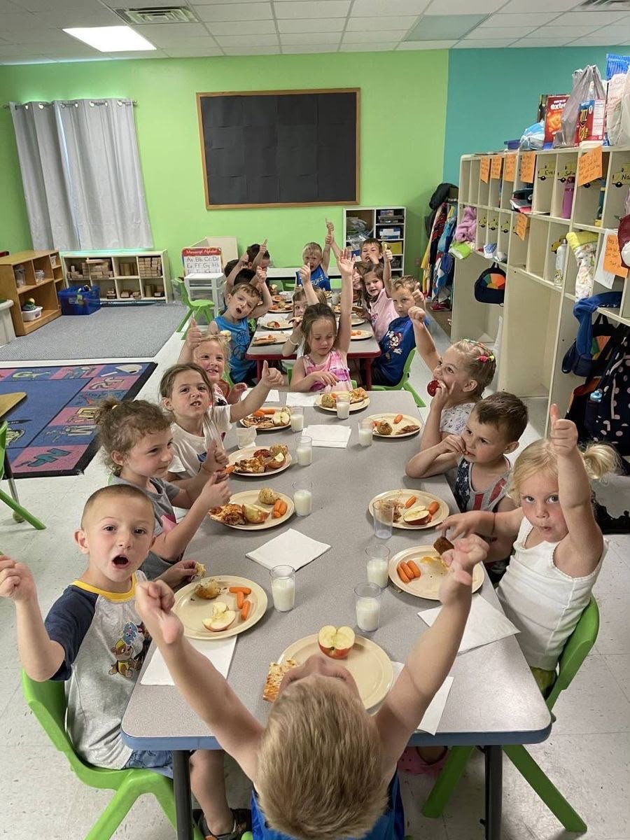 Children gathered around a table in a classroom