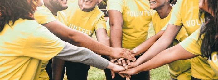 Volunteers joining hands in a circle